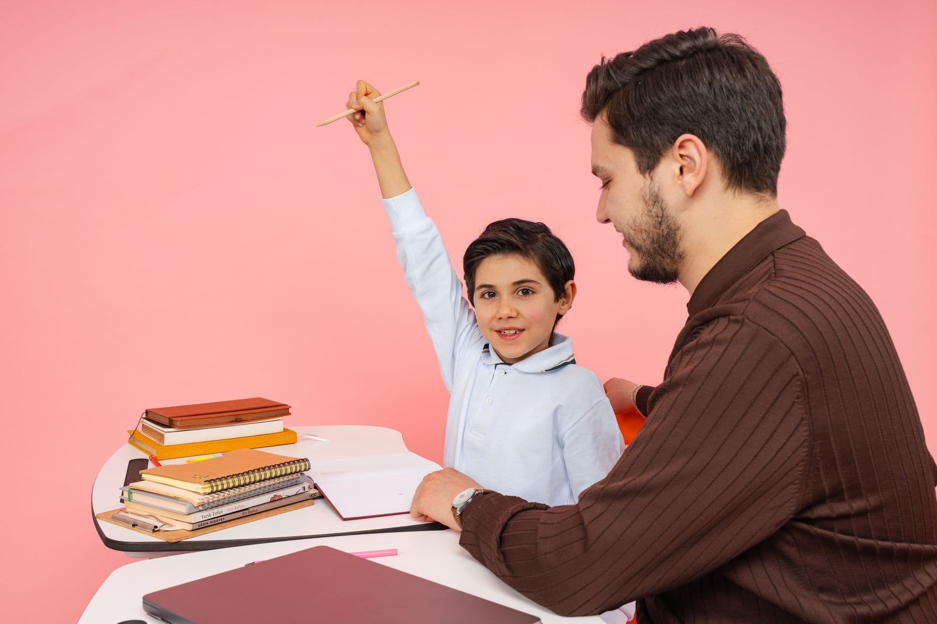 A young child raising a hand in a classroom