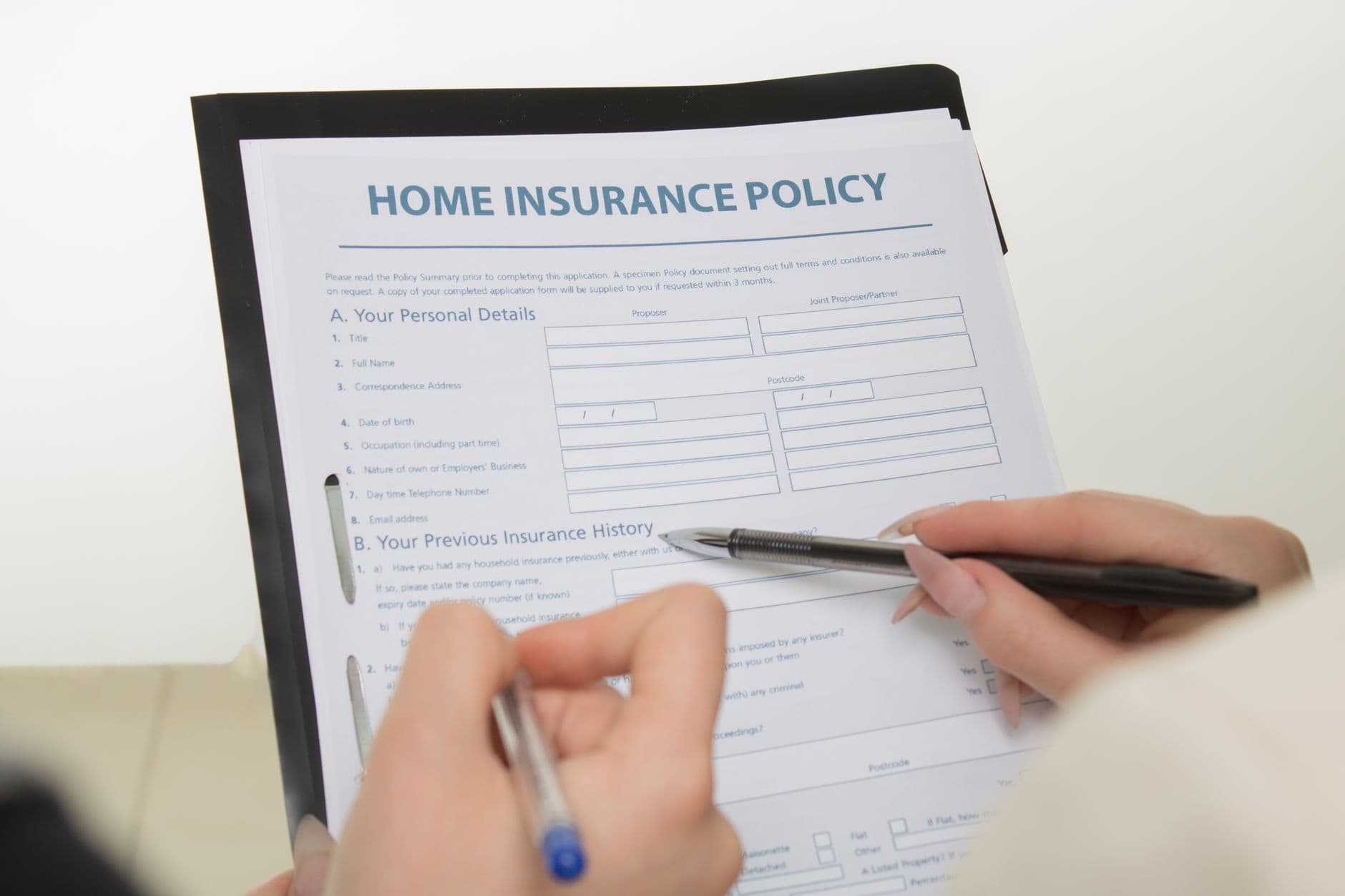 A mother filling out medical insurance forms at a table at home