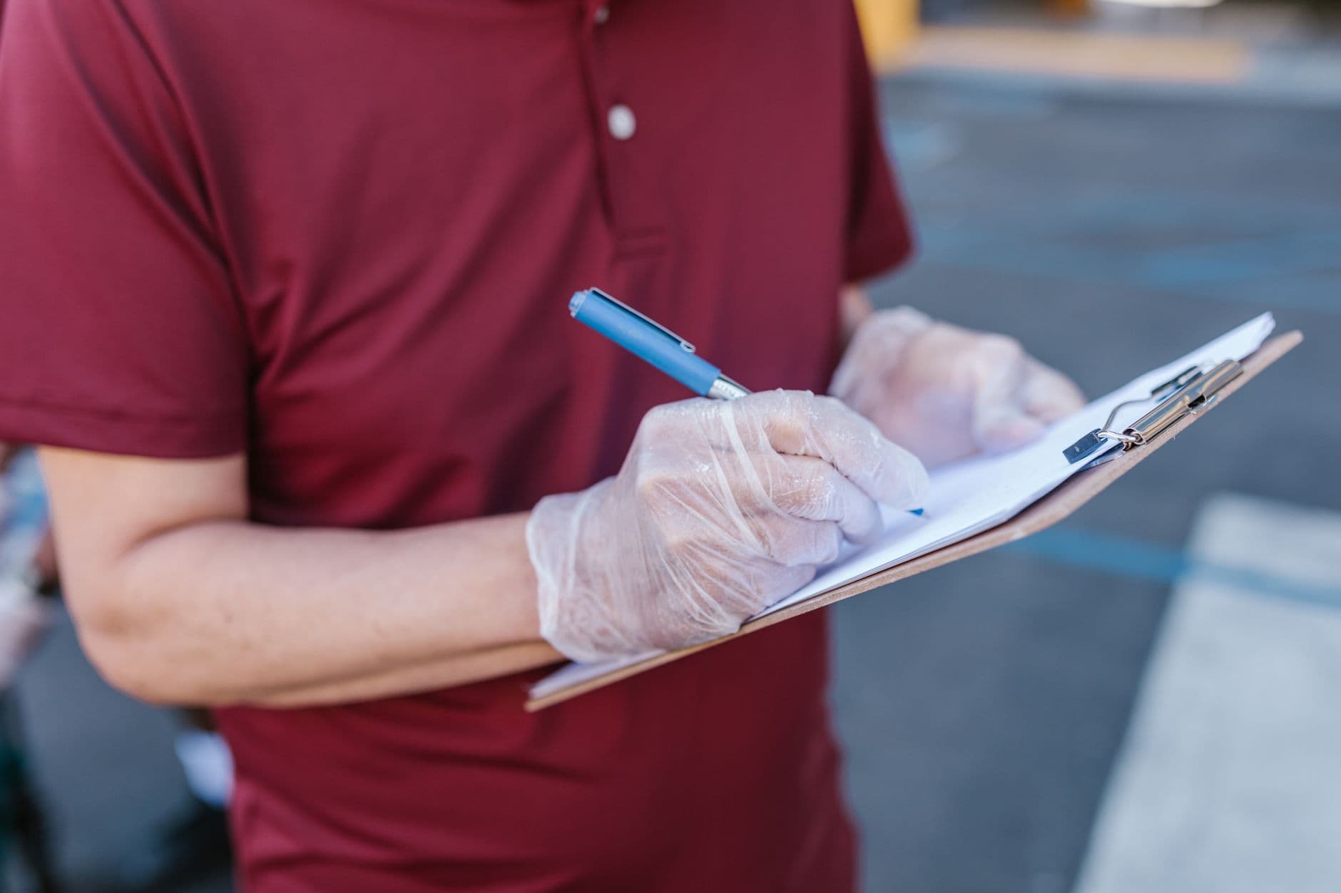 A person writing a checklist on a clipboard