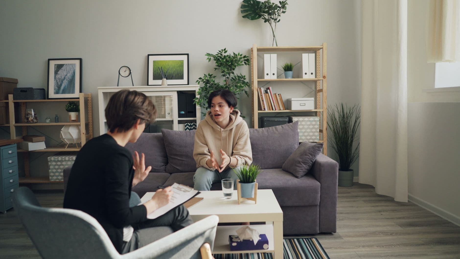 A speech therapist working face to face with a young child at a table