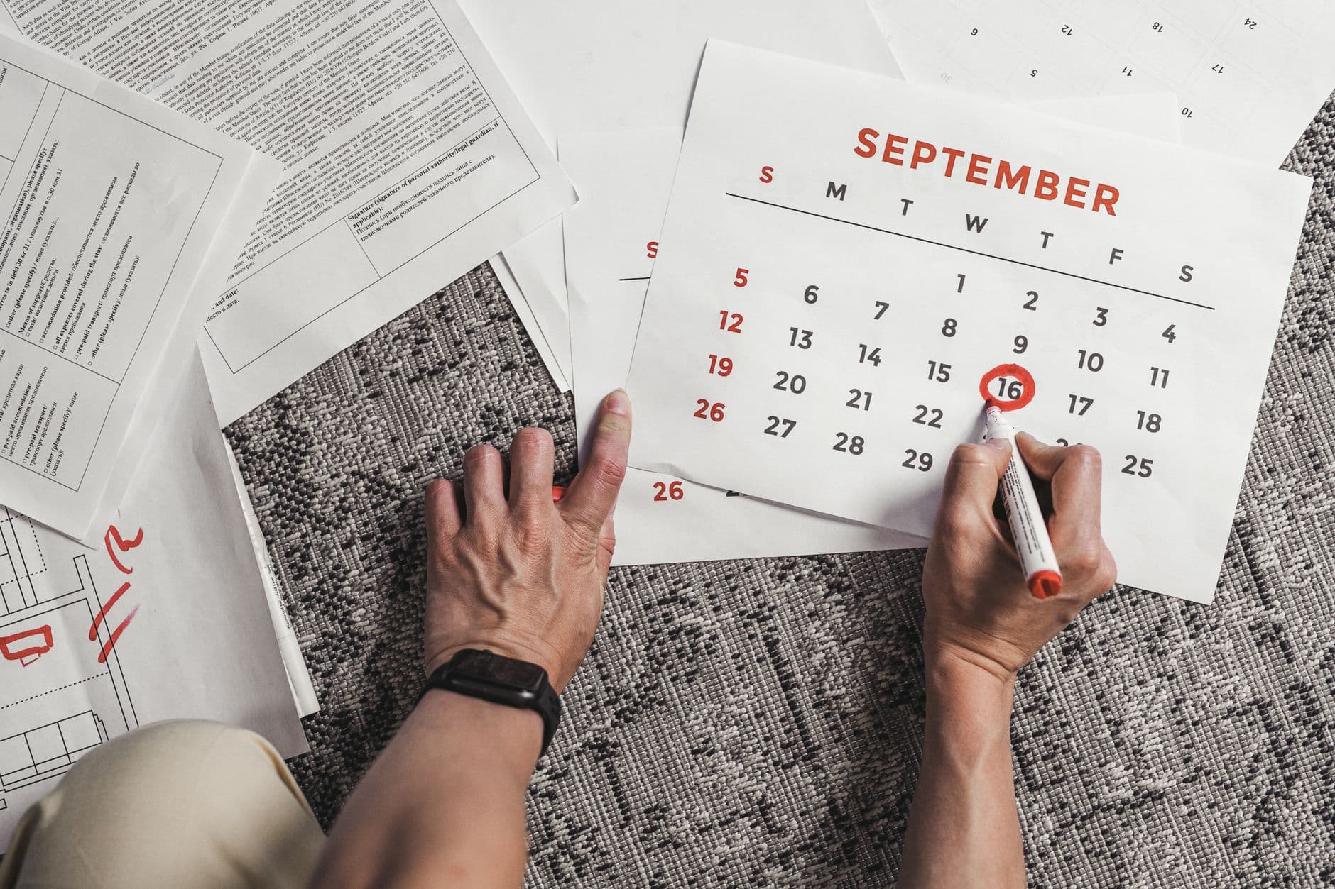 A parent reviewing a calendar planner at a desk