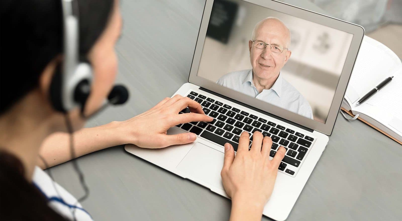 SLP using laptop for online speech therapy with adult