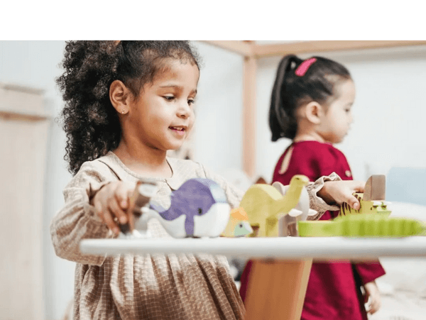 little girl playing with toys on the table