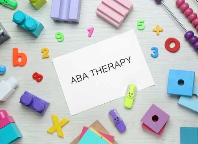 ABA Therapy text on a card with colorful toys, blessed aba therapy spring