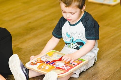 child with autism playing with a puzzle