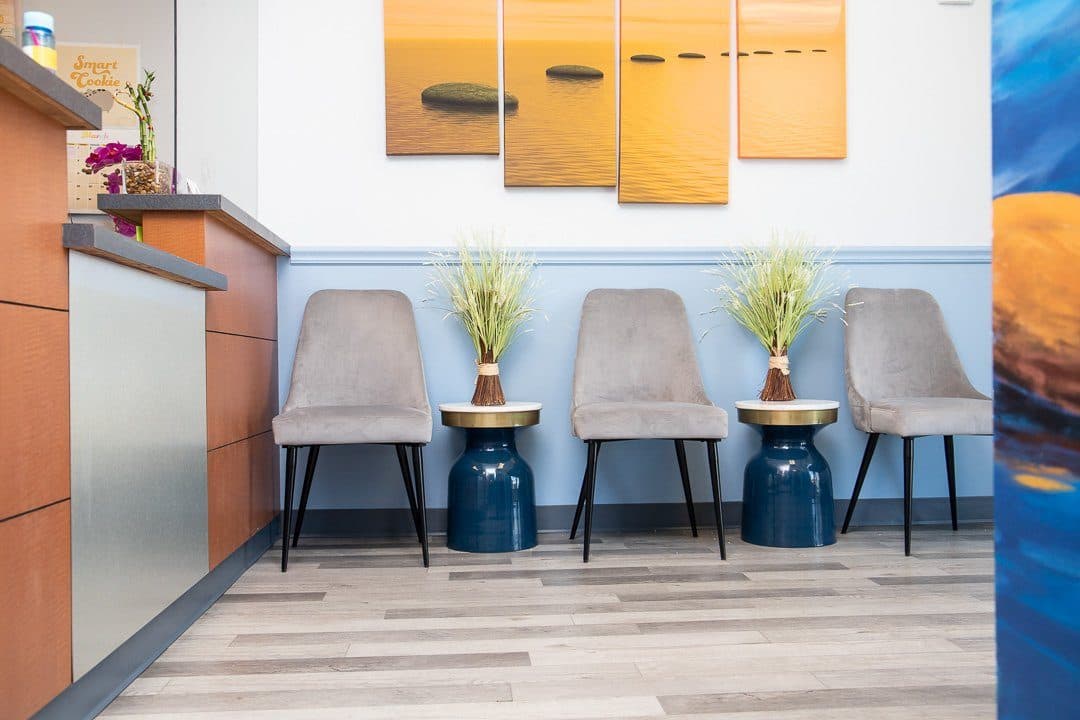 stepping stones main lobby entrance with two gray chairs and yellow wall artwork