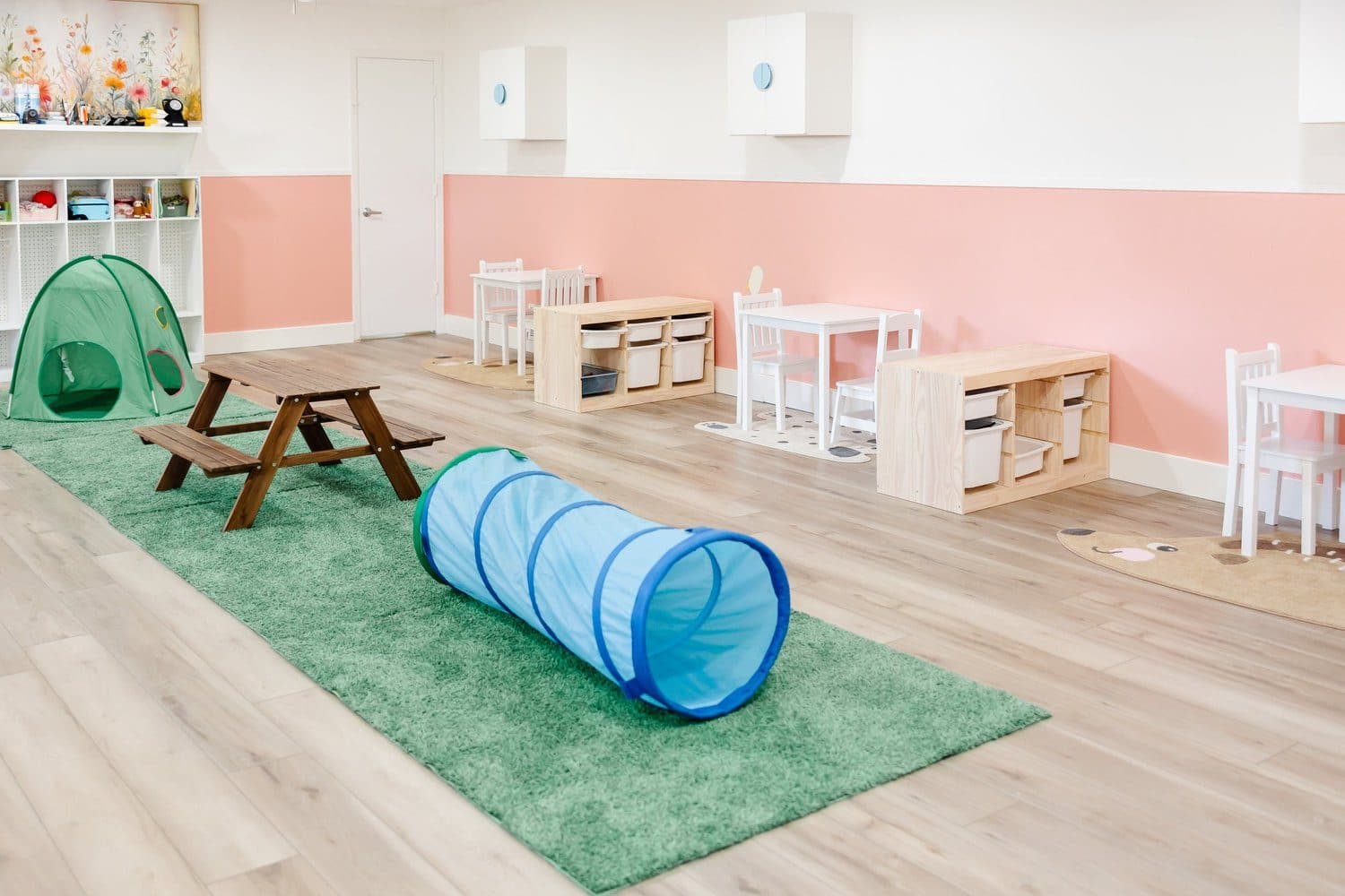 Middle room featuring toys, tables, and a variety of learning stations